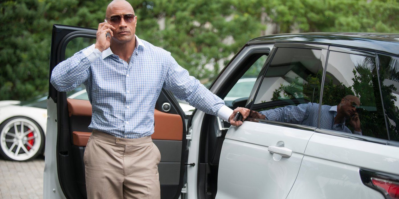 Spencer (The Rock) in Ballers leaning against his car and talking on a cellphone