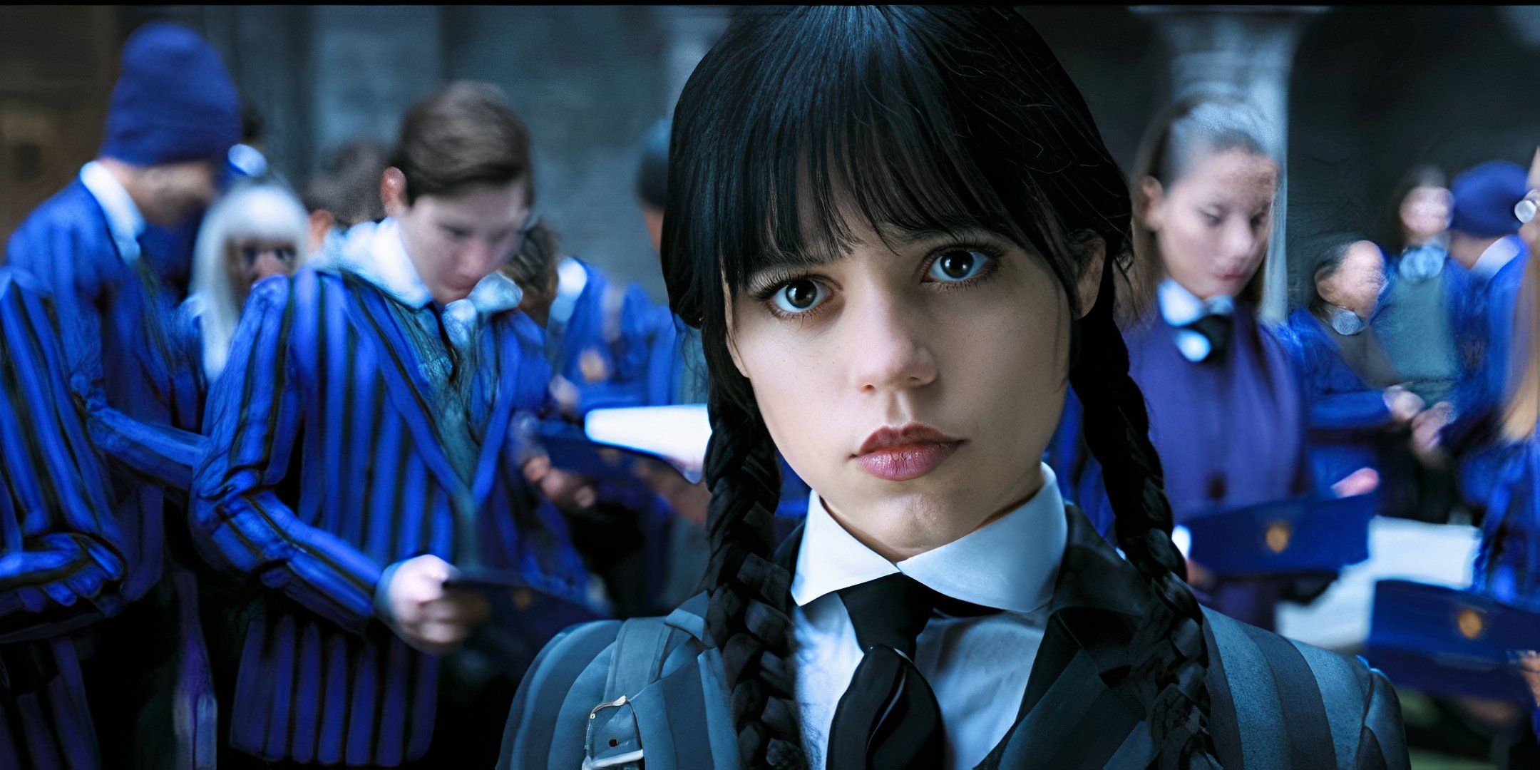 Jenna Ortega as Wednesday Addams, standing in the foreground with a group of students in blue striped uniforms in the background