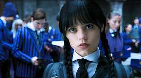 Jenna Ortega as Wednesday Addams, standing in the foreground with a group of students in blue striped uniforms in the background