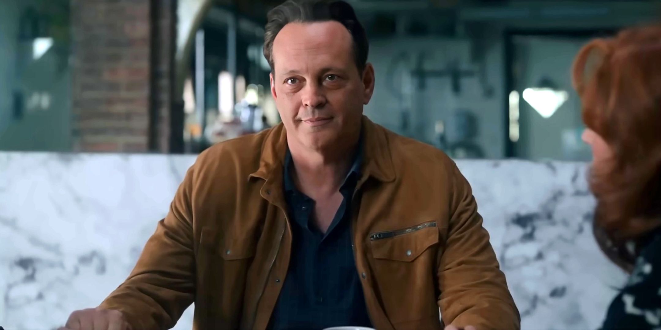 Vince Vaughn as Joe smiling while sitting at a table with the group in Nonnas