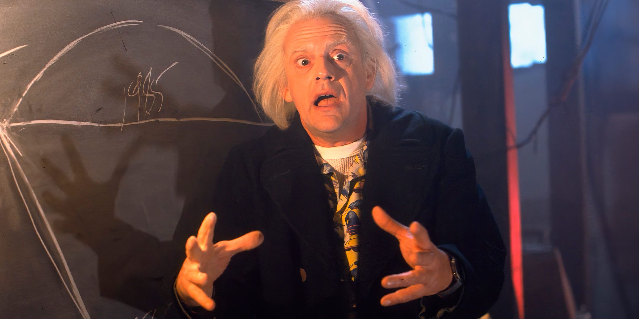 Doc Brown gesticulates with his hands while taking in front of his chalkboard in Back to the Future Part II