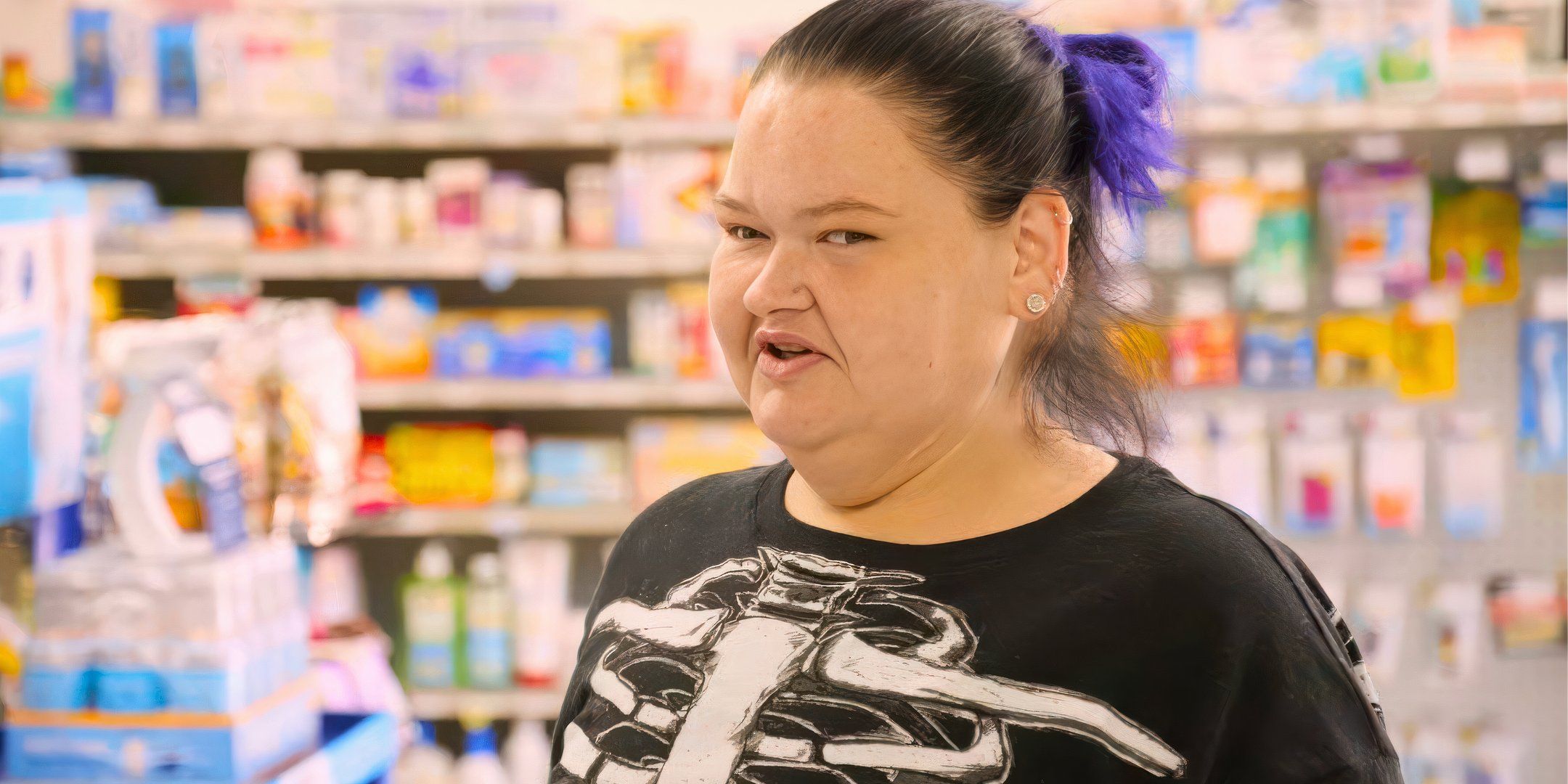 1000 lb sisters star Amy Slaton in a chain store with purple hair and a skeleton print shirt
