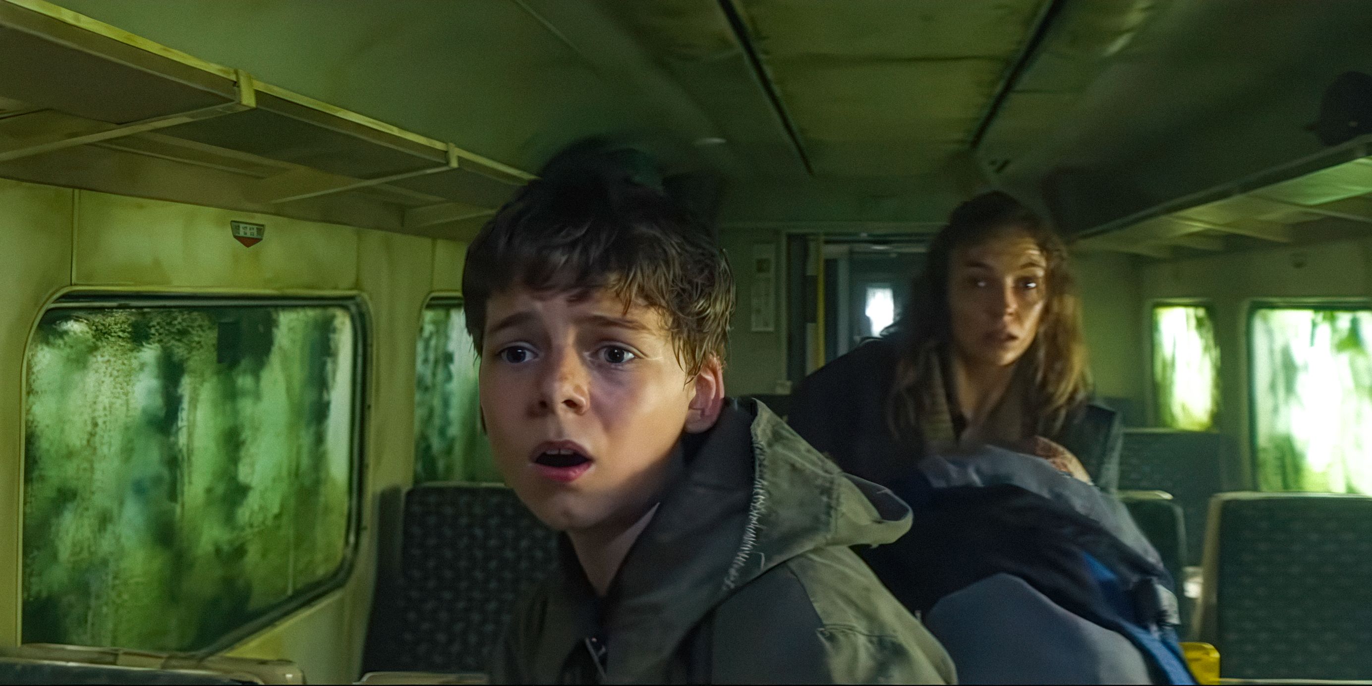 Spike (Alfie Williams) and Isla (Jodie Comer) are looking scared in the train in 28 Years Later
