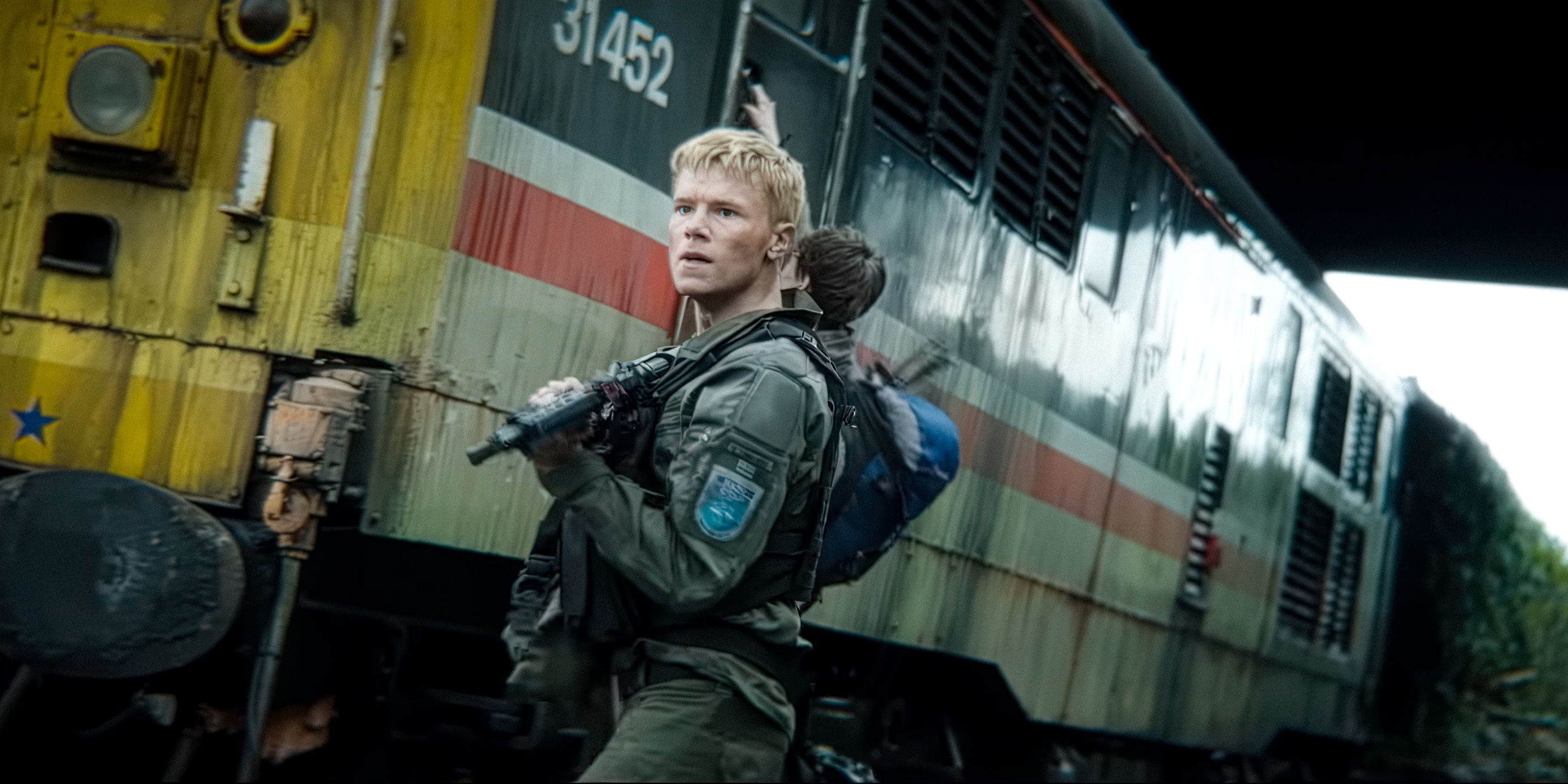 Edvin Ryding as Erik Sundqvist looking nervous outside a train in 28 Years Later