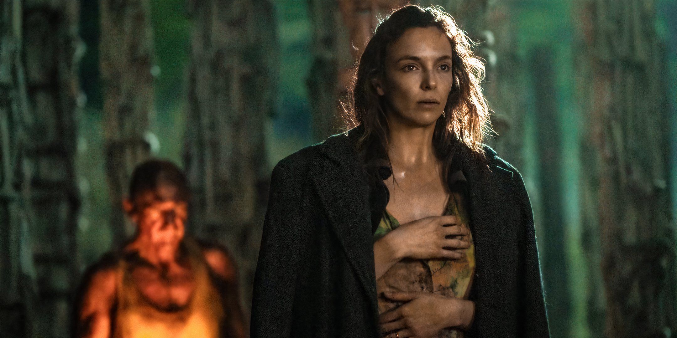 Jodie Comer as Isla walking while Dr. Kelson is behind her in 28 Years Later