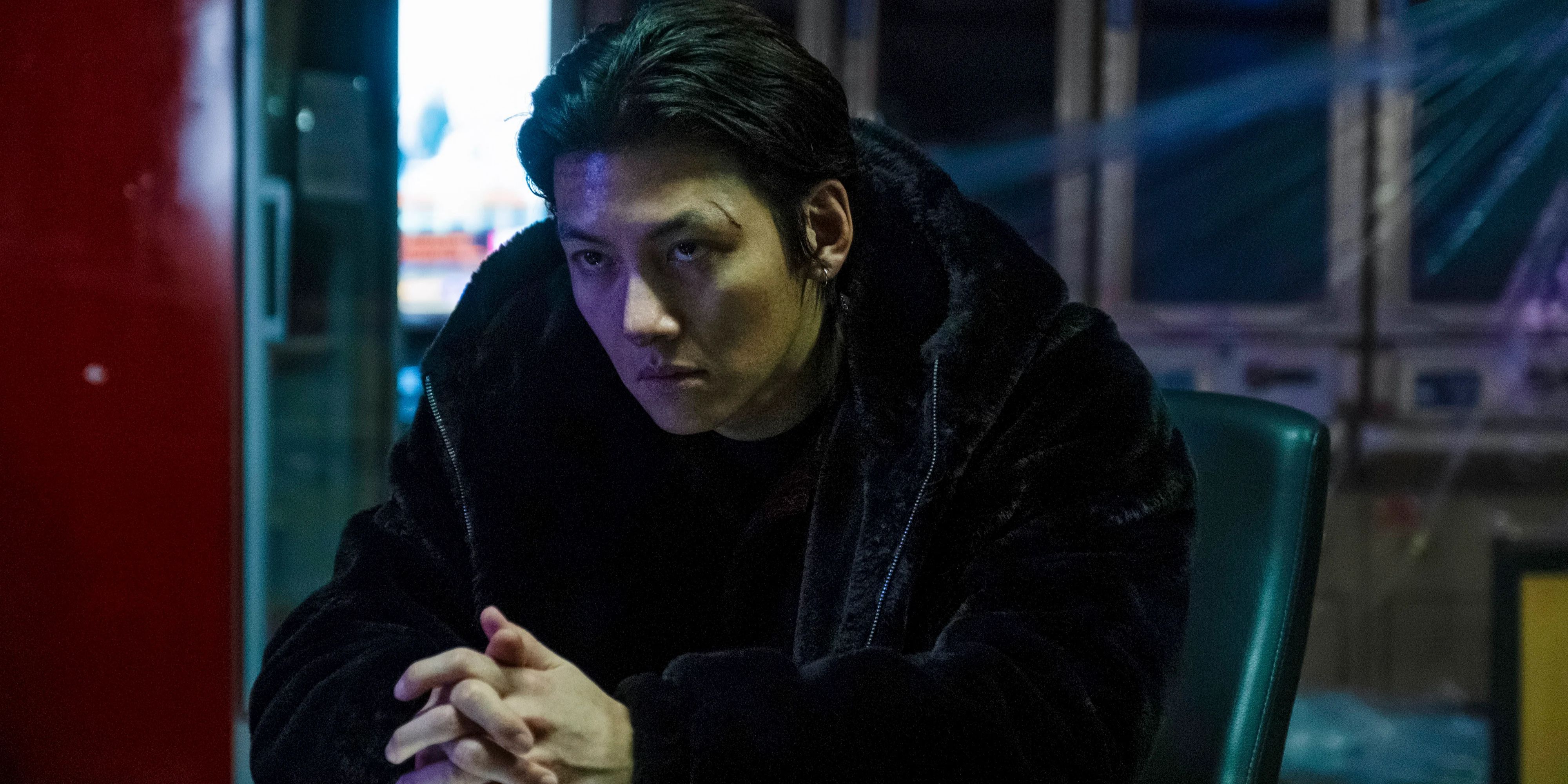 A bad guy in Gangnam B-side sitting with his hands folded