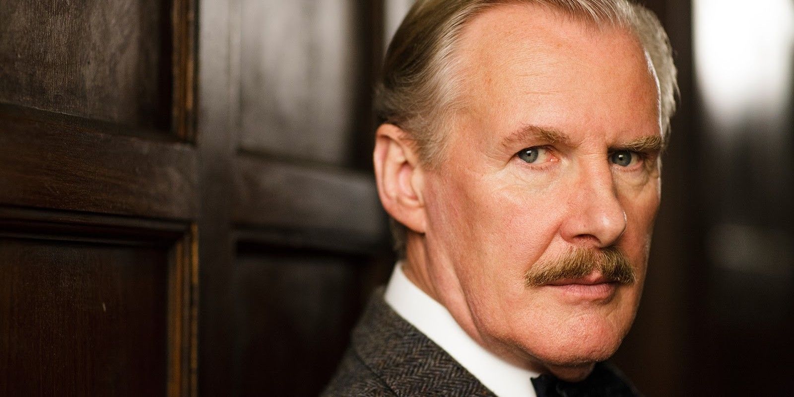 a close-up of Dr Clarkson looking at the camera in Downton Abbey