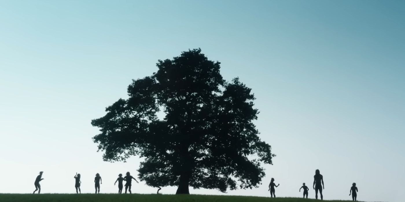 A group of Infected silhouetted on a hilltop by a tree in 28 Years Later