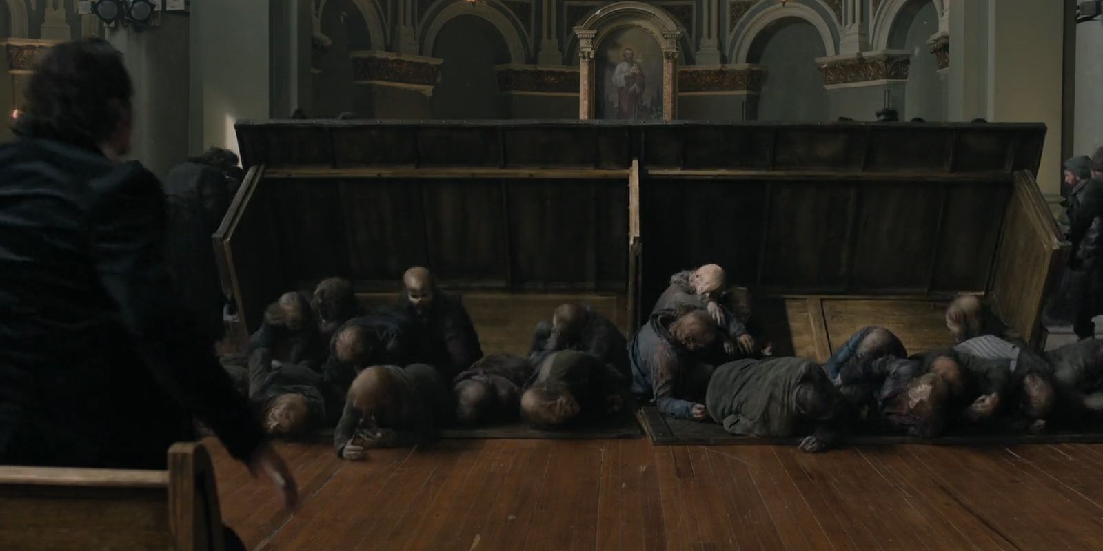 A group of zombies crawling from under a table in The Walking Dead: Dead City season 2