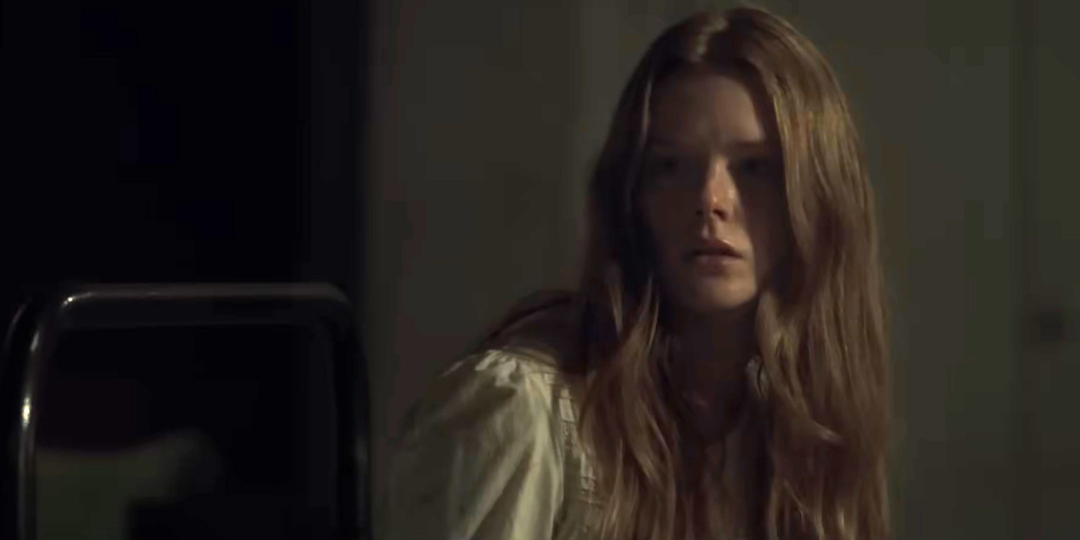 Abigail Cowen as Emma looking worried while sitting up in bed in The Ritual