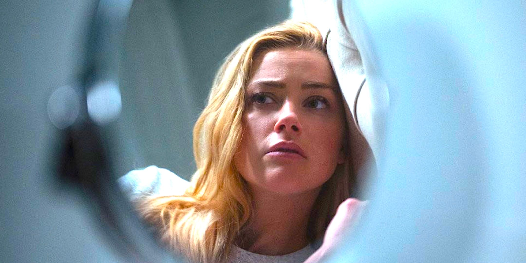 Amber Heard's Nadine looks worried in a mirror from The Stand 2020