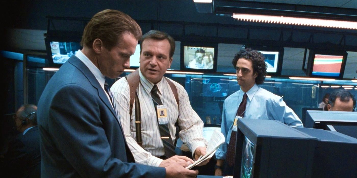 Arnold Schwarzenegger and Tom Arnold looking at a file in True Lies