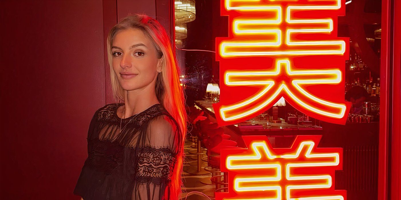 Below Deck season 12's Rainbeau du Roos smirking in front of a neon sign.