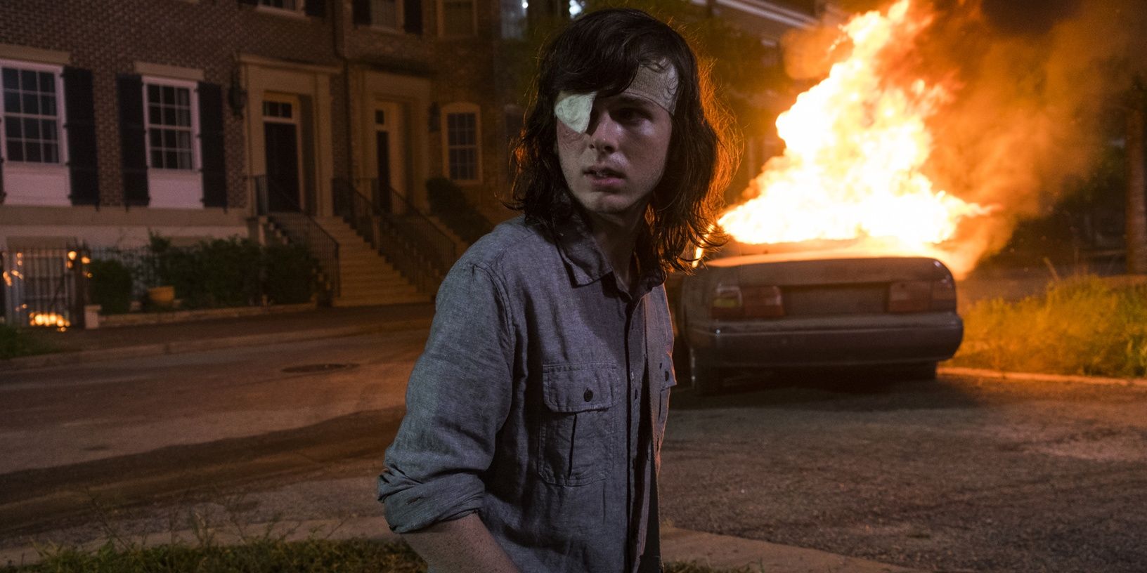 Carl in front of a fire in The Walking Dead