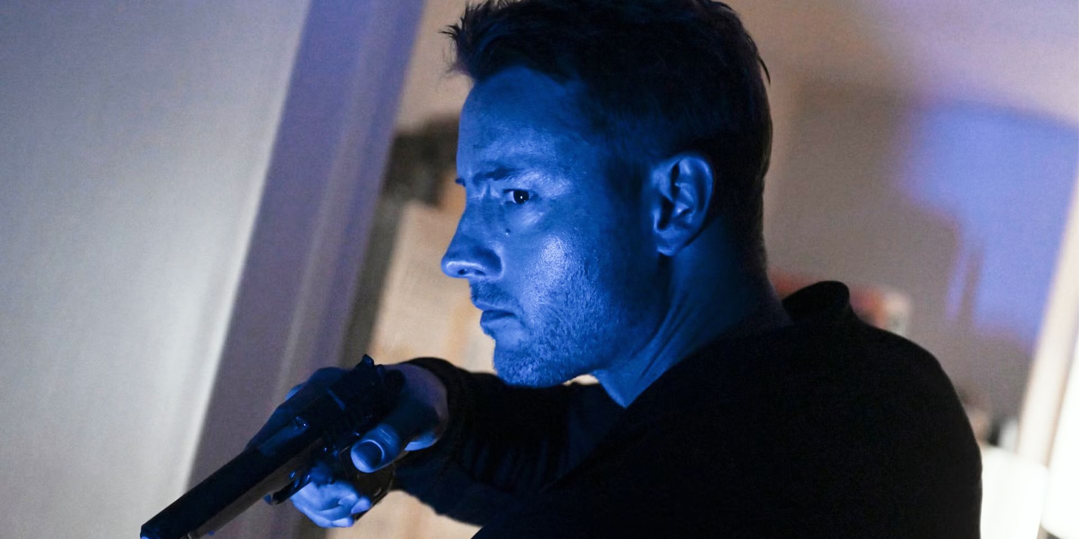 Colter Shaw com a arma em punho nas sombras em Tracker