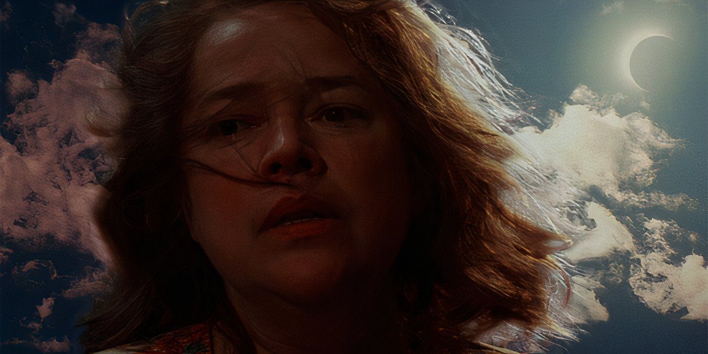 Dolores looks down with the eclipse in the sky behind her in Dolores Claiborne