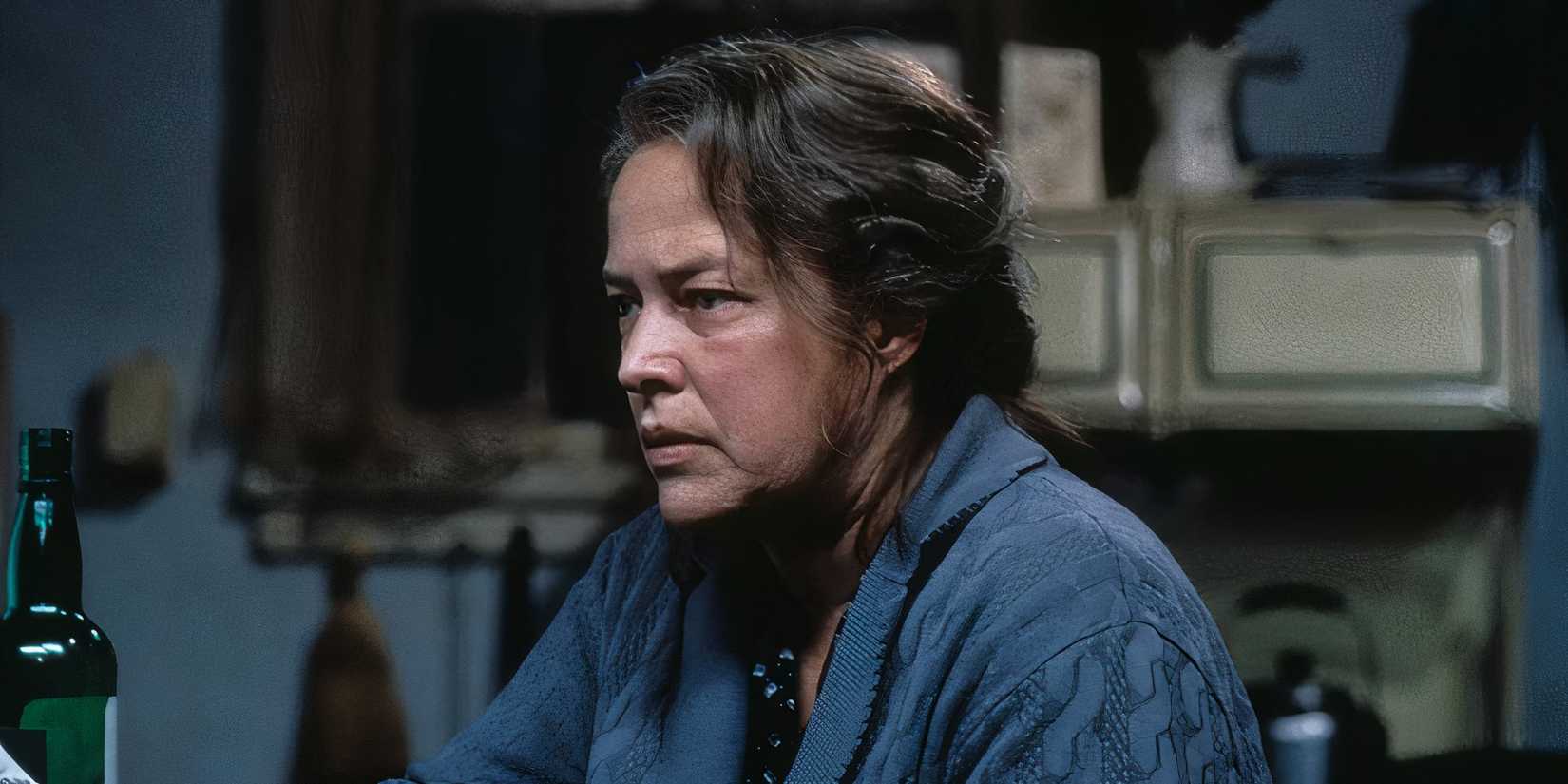 Dolores looks on angrily while sitting at the table in Dolores Claiborne