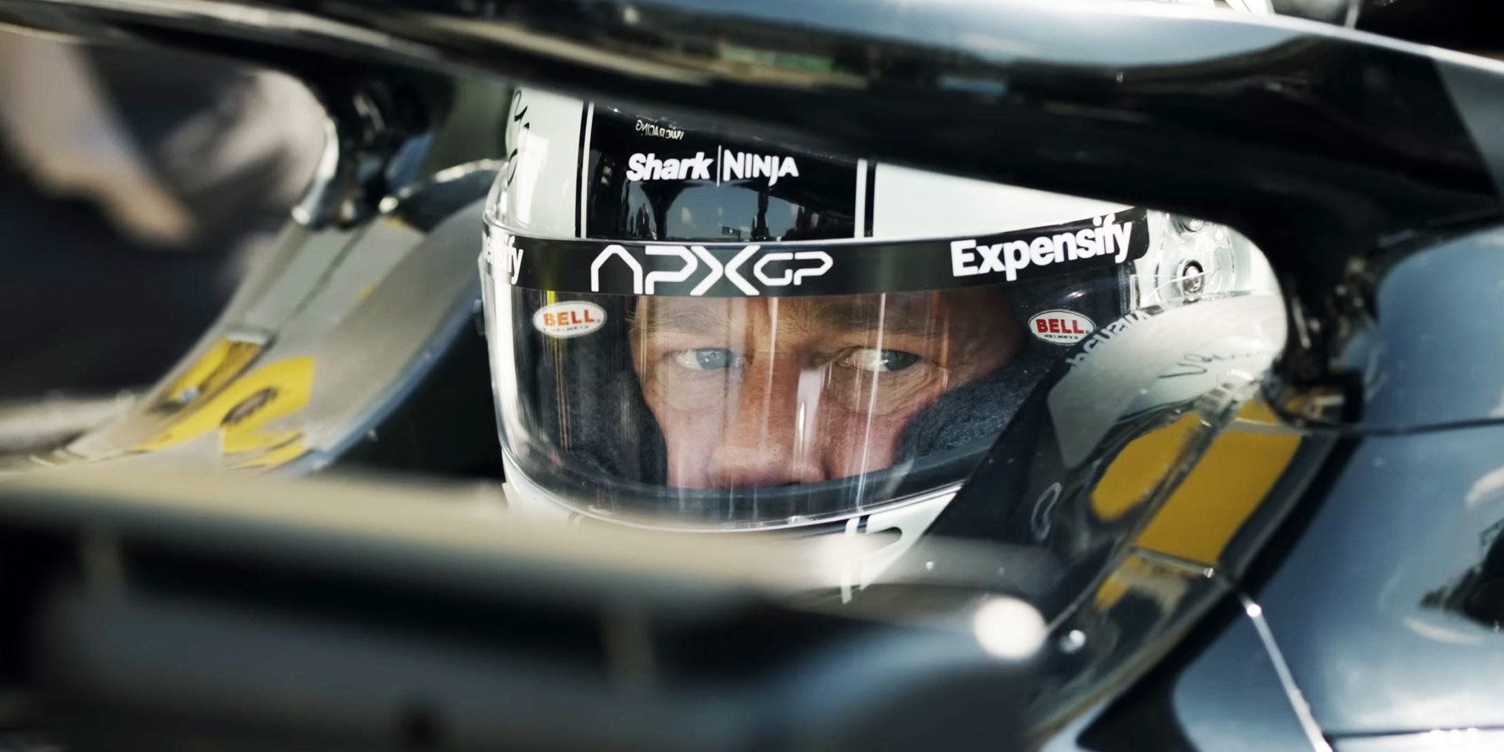 Brad Pitt as Sonny Hayes in the driver's seat of an F1 car in F1: The Movie