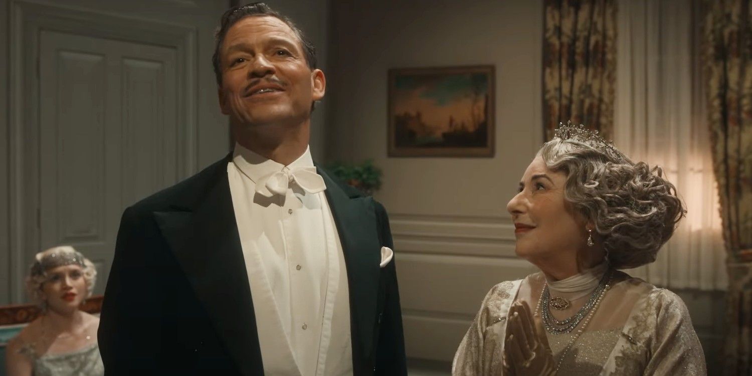 Guy Dexter speaking grandly while an older woman smiles up at him in Downton Abbey The Grand Finale