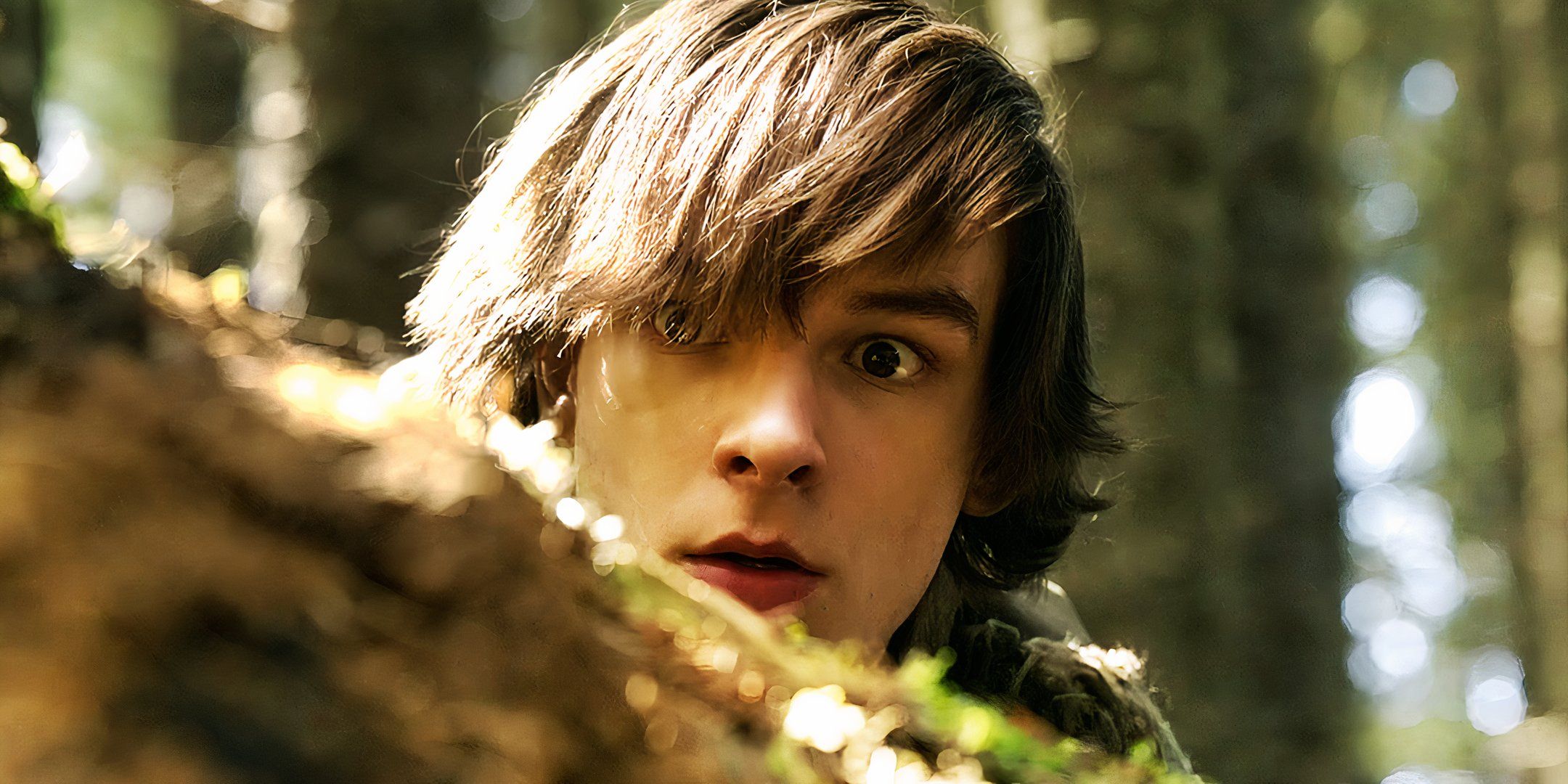 Mason Thames as Hiccup hiding behind a rock in How to Train Your Dragon 2025