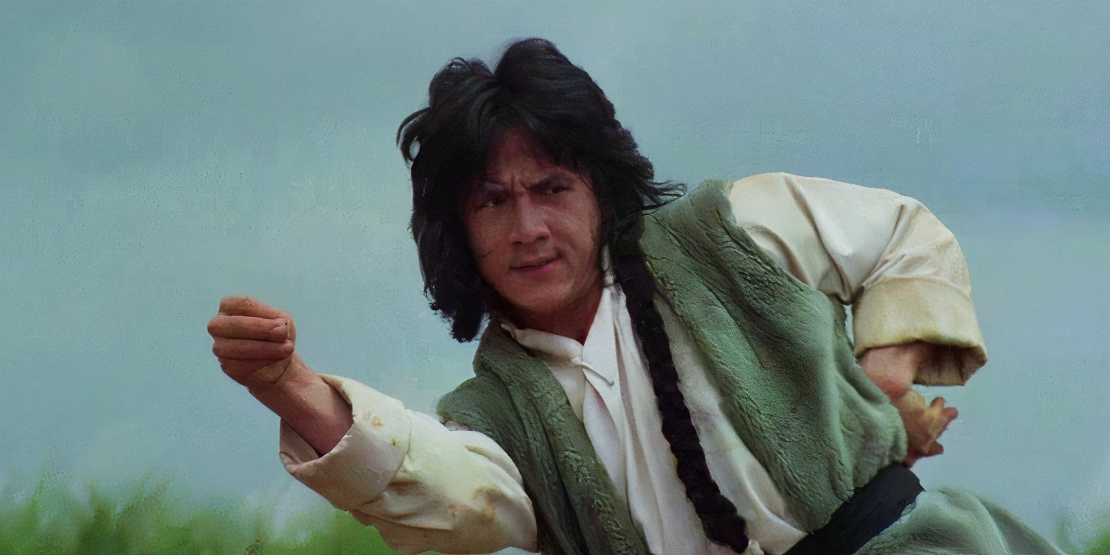 Jackie Chan stands in a fighting pose. 