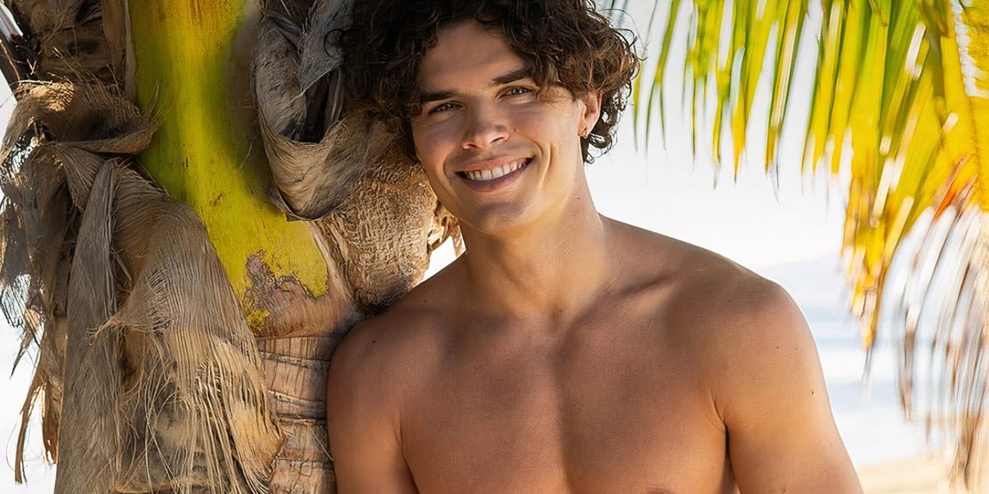 Love Island USA Season 7's Nic Vansteenberghe smiling under a palm tree.