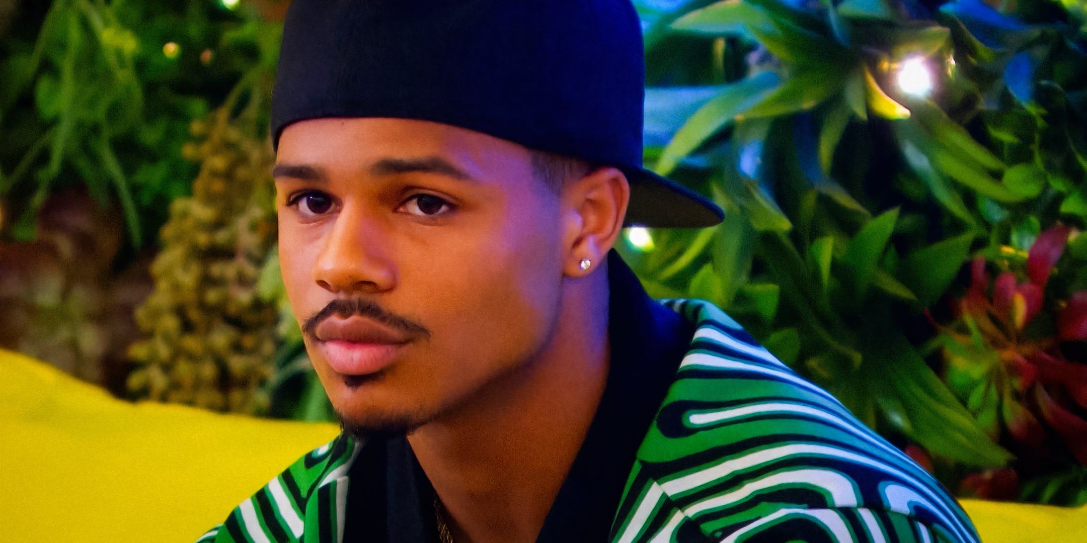 Love Island USA Star Ace Greene looks dark in a motionless with plants in the background