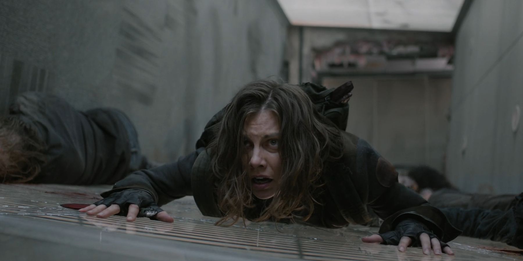 Maggie (Lauren Cohan) looking concerned as she lays on a bridge in The Walking Dead: Dead City season 2