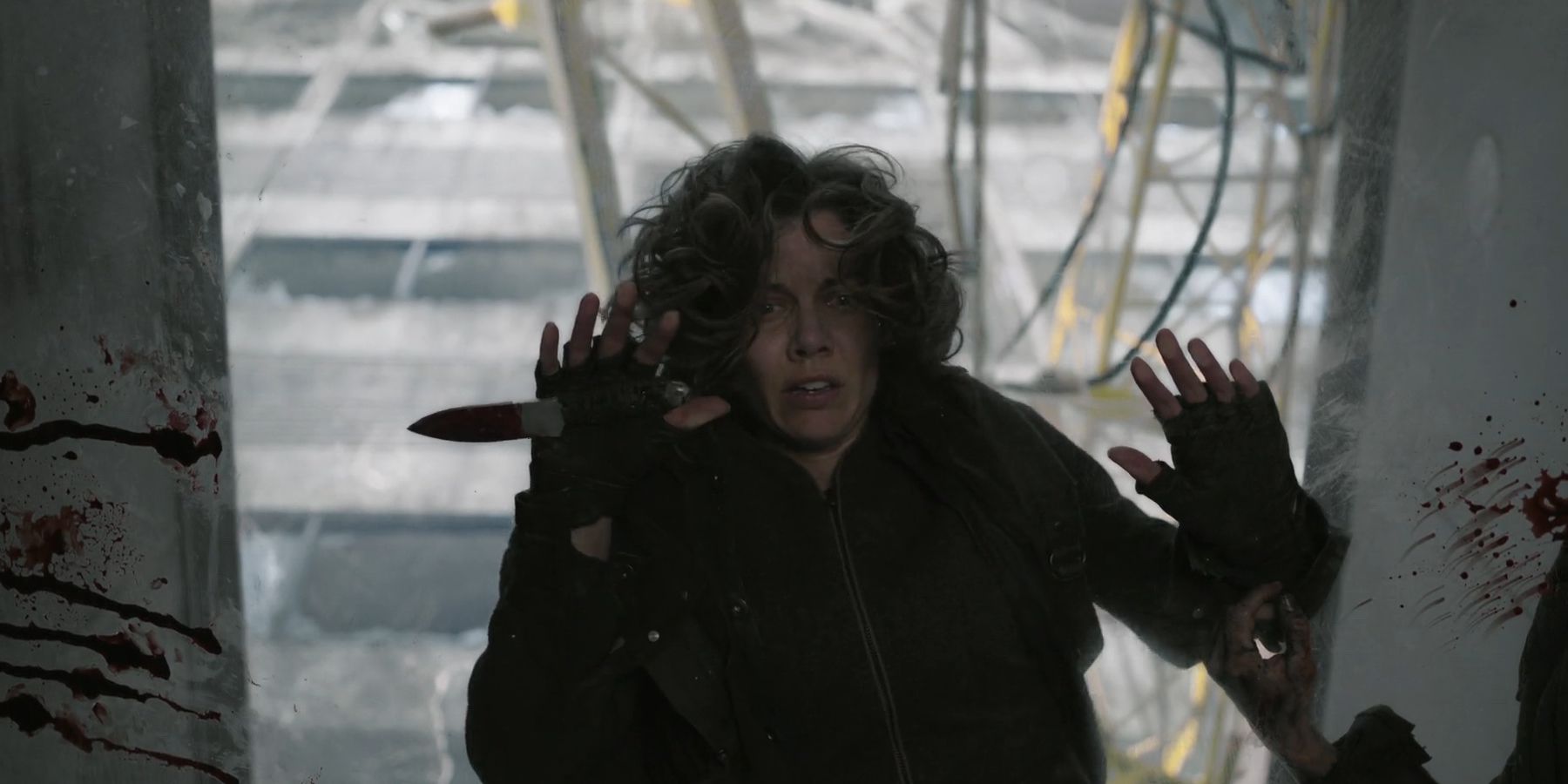 Maggie (Lauren Cohan) looking terrified as she looks down a glass bridge in The Walking Dead: Dead City season 2