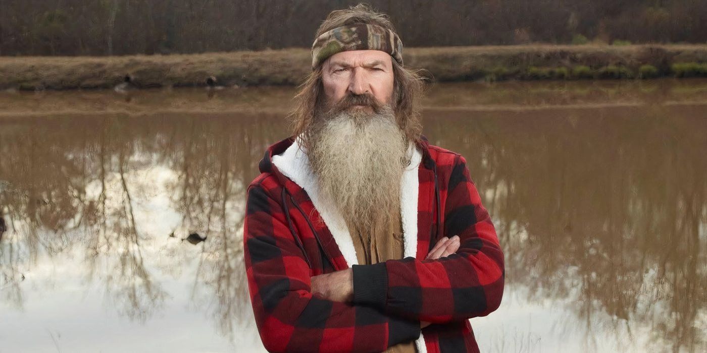 Phil Robertson in Duck Dynasty posing outdoors with crossed arms in plaid