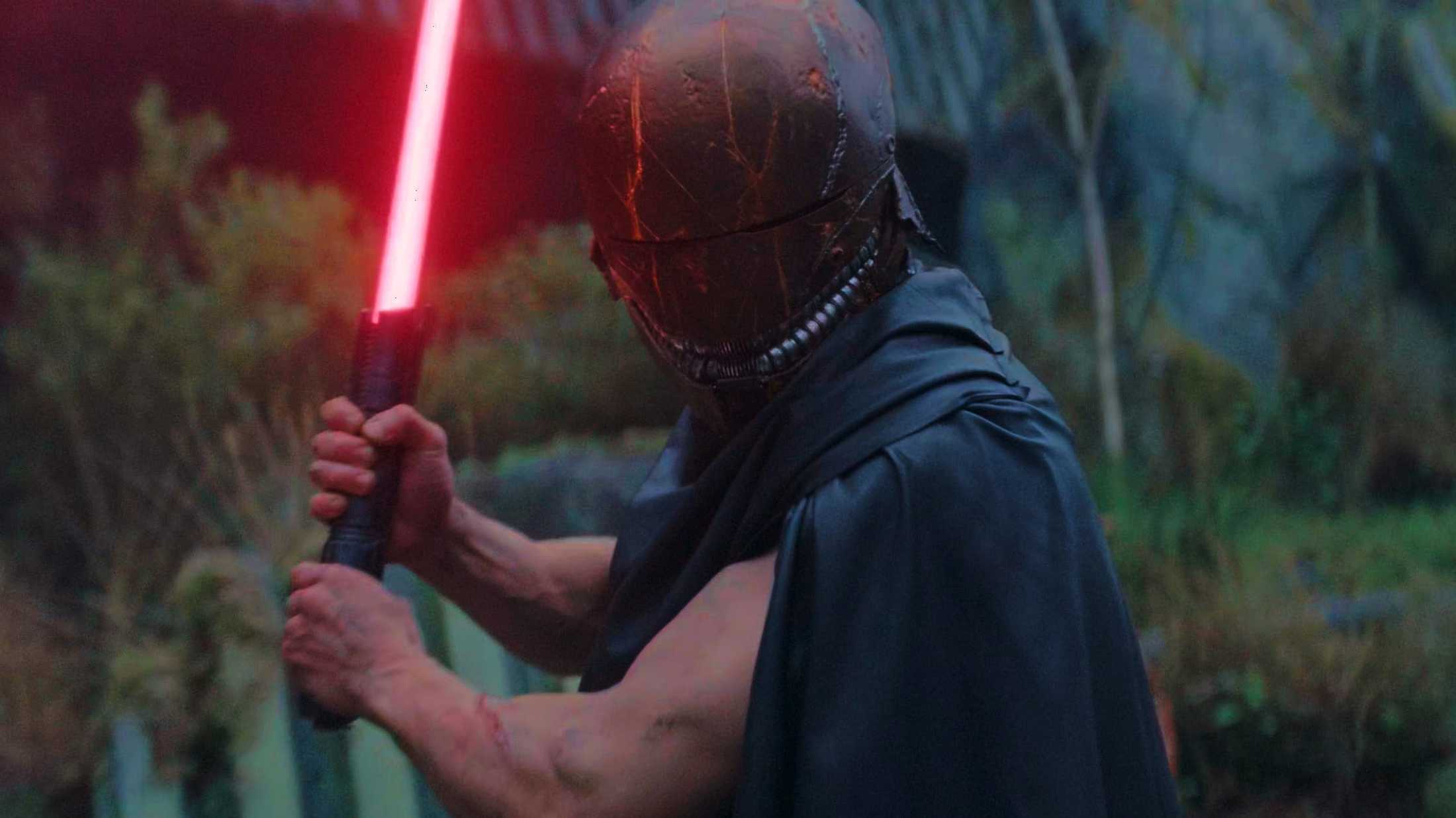 Qimir/ Stranger empunhando um sabre de luz vermelho em The Acolyte