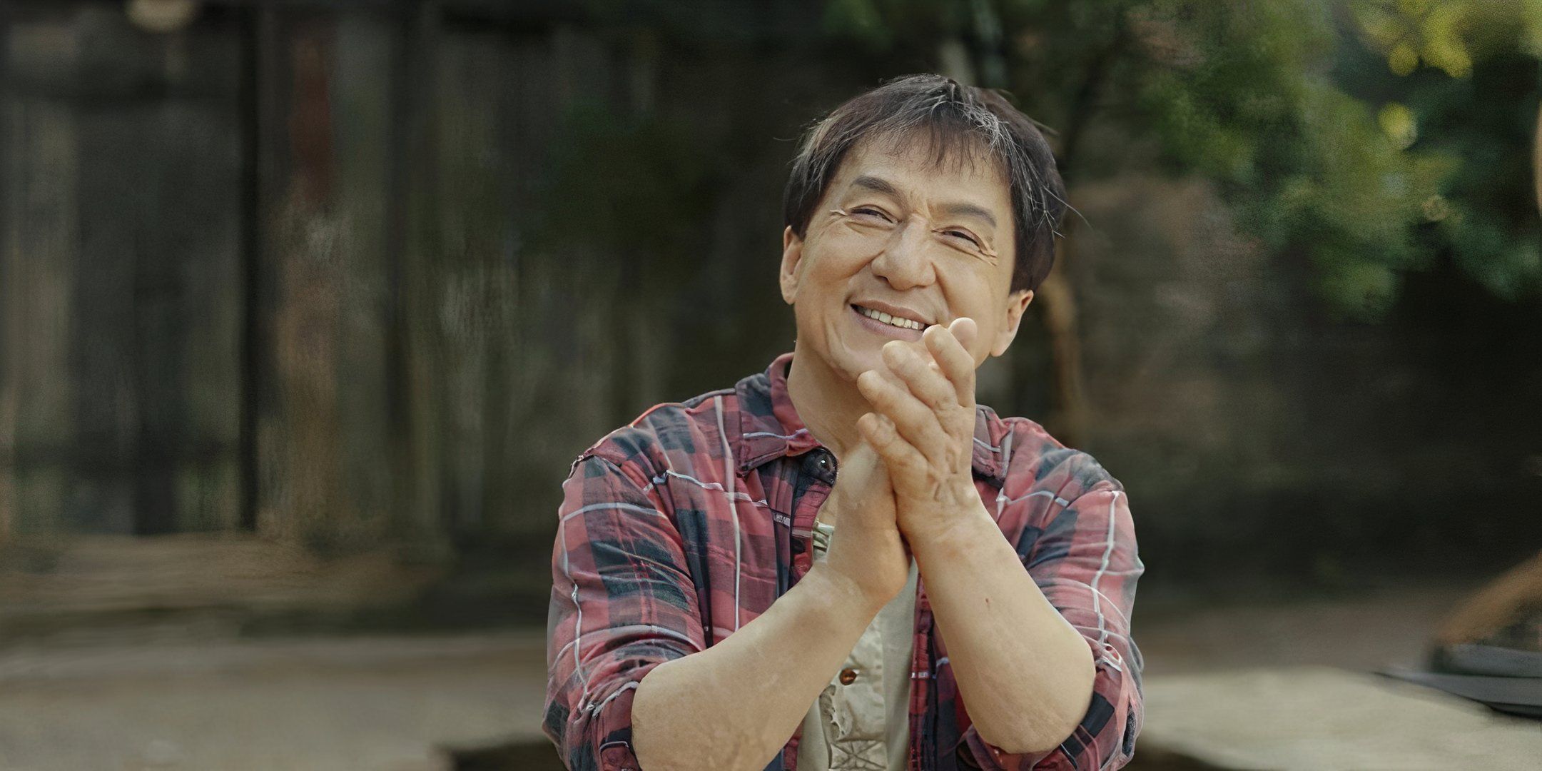Jackie Chan claps his hands happily in Ride On. 