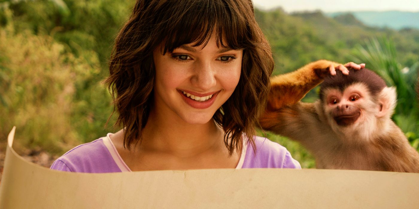 Samantha Lorraine as Dora smiling with Boots on her shoulder while looking at Map in Dora and the Search for Sol Dorado
