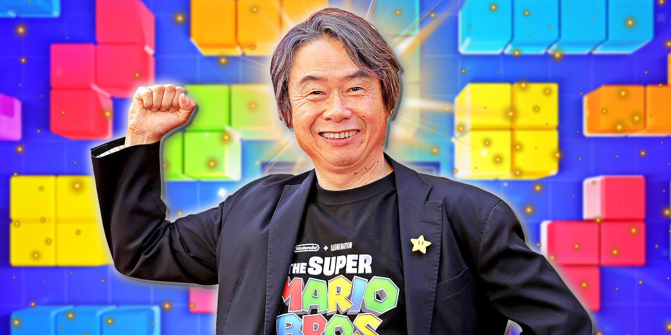 Shigeru Miyamoto raises a fist in a Mario pose in front of Tetris tiles.
