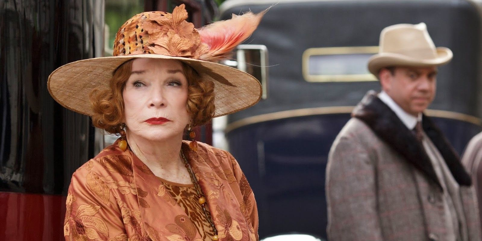 Shirley MacLaine as Martha Levinson looking off to the side while Harold stands in the background on Downton Abbey