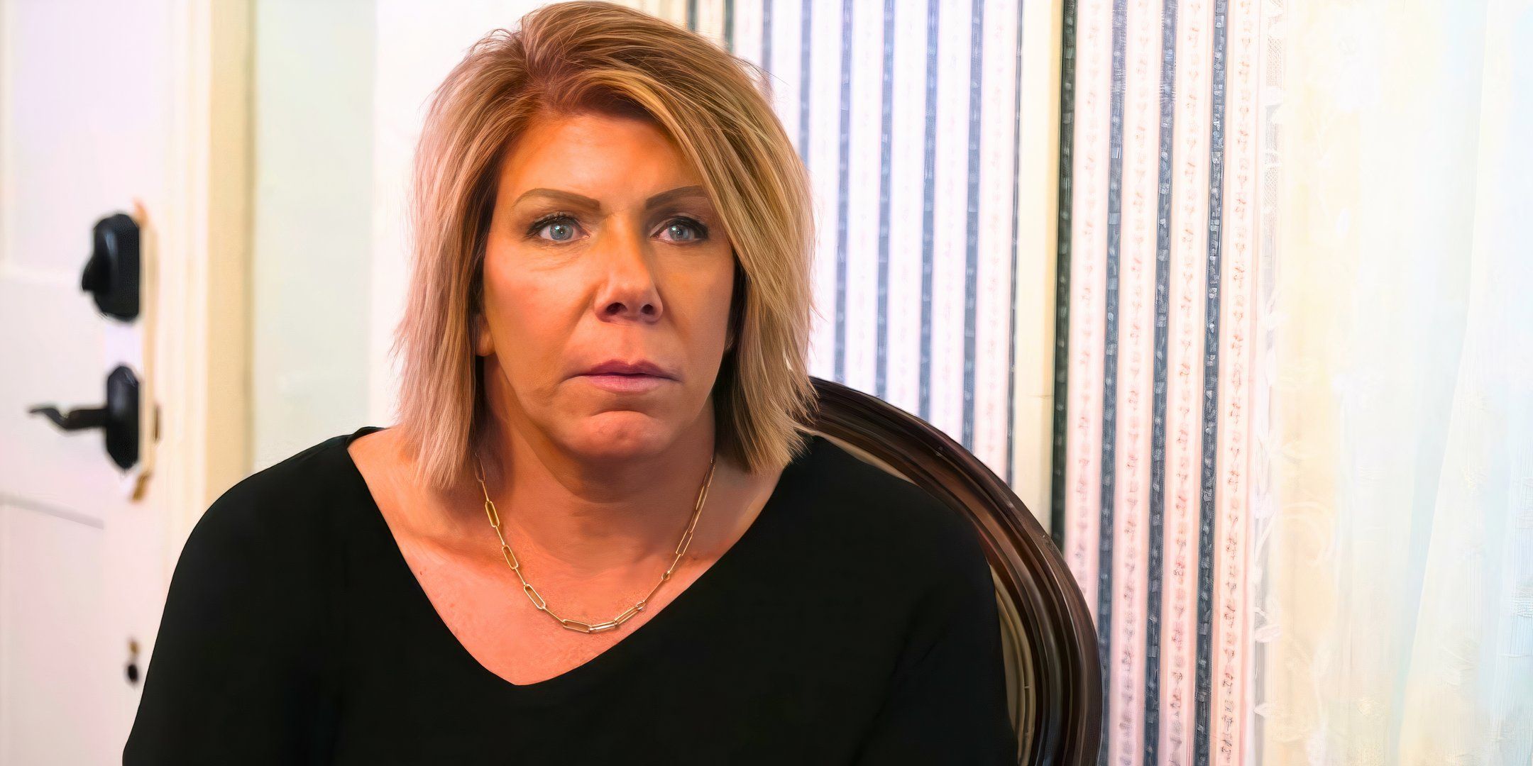 sister wives star meri brown in a black top looking miserable with a white background
