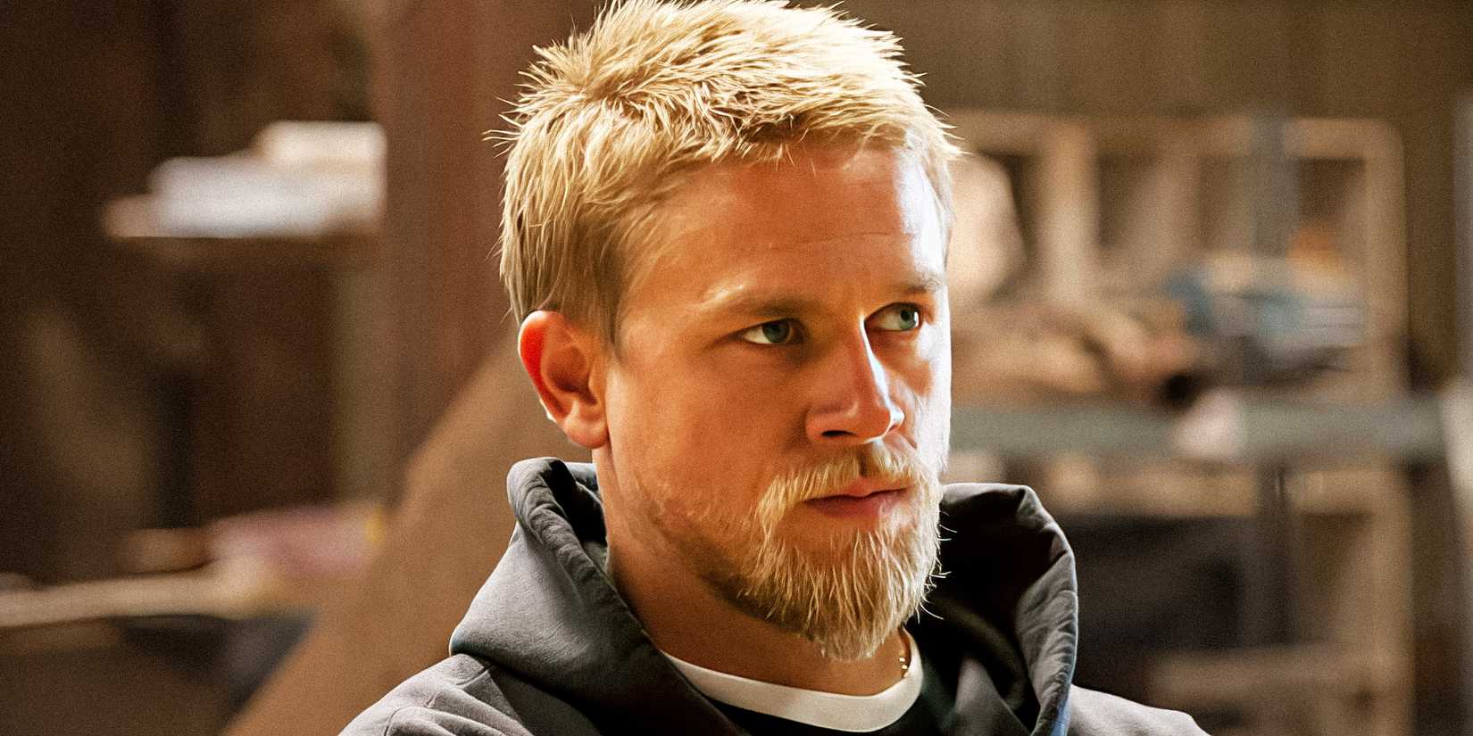 Charlie Hunnam as Jax Teller with shorter hair wearing a black hoodie in Sons of Anarchy
