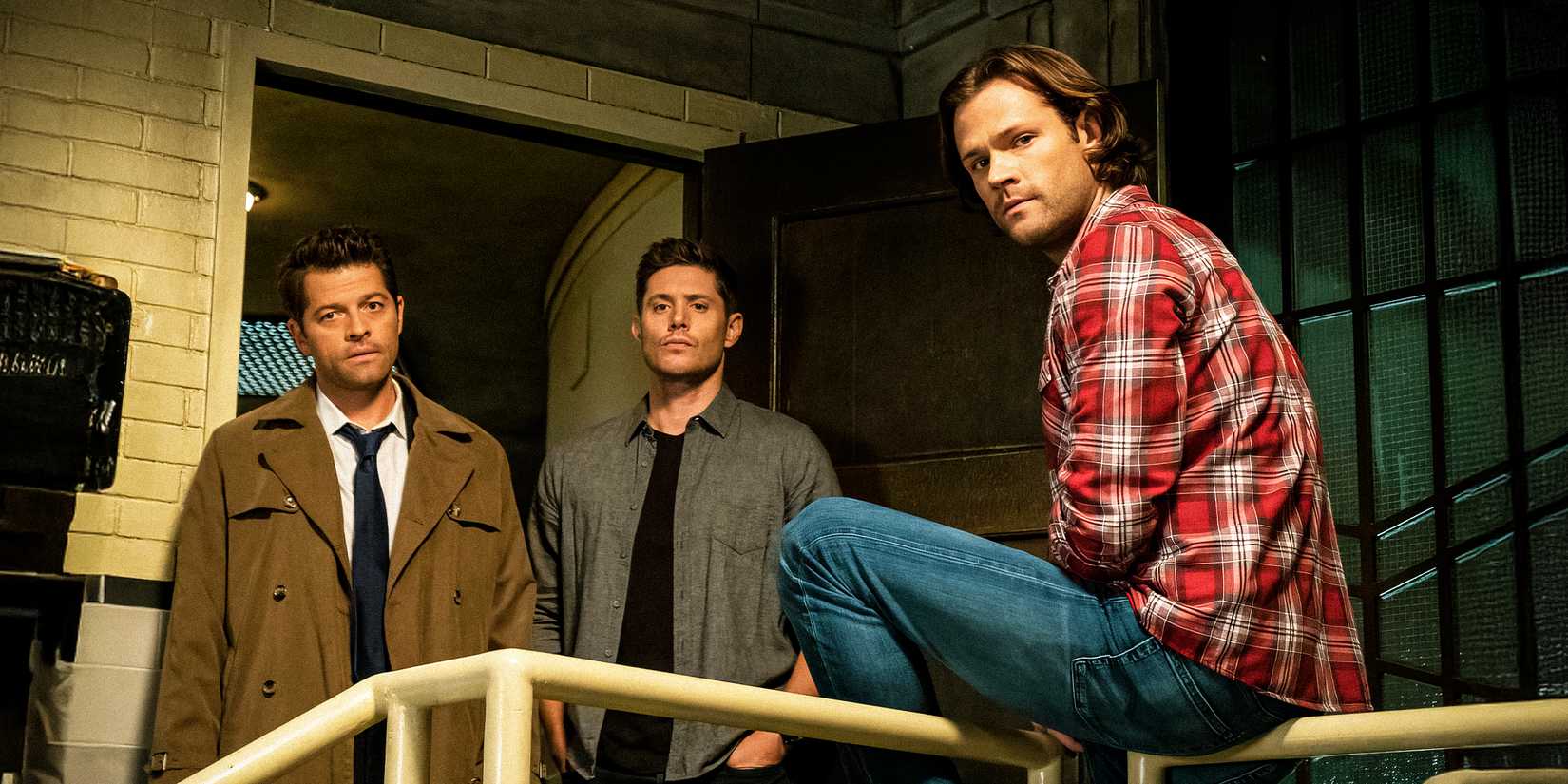 Sam (Jared Padalecki), Dean (Jensen Ackles), and Castiel (Misha Collins) all sitting in a room in Supernatural.
