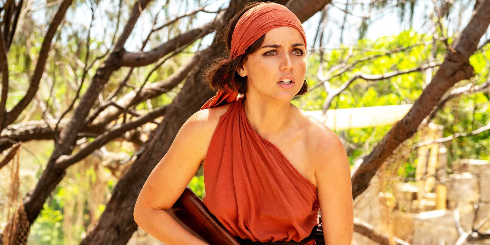 Ana de Armas looking perturbed while holding a gun in Eden