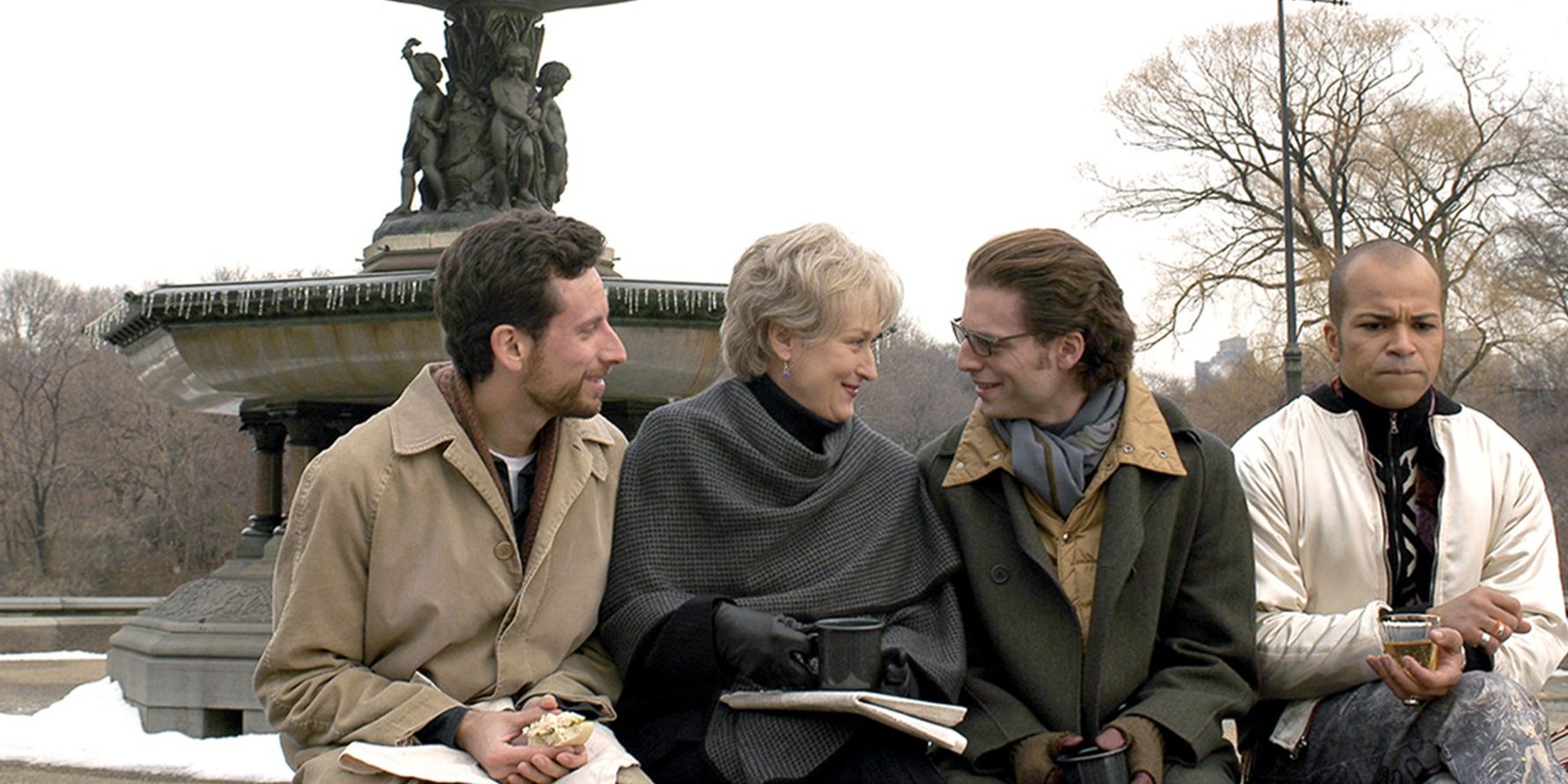 The cast sitting on a fountain in Angels in America