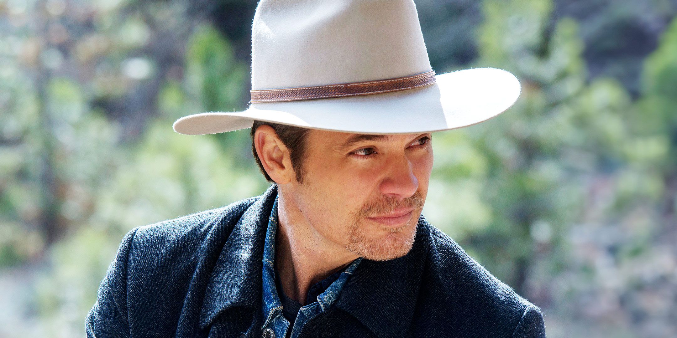 Timothy Olyphant as Raylan Givens looking off to the side with a smug expression in Justified