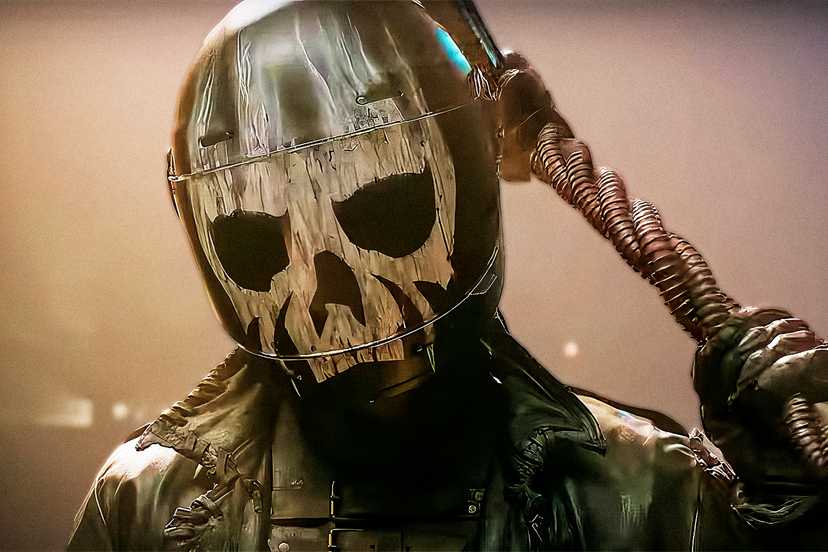 A close-up of Mr. Grimm wearing a skull mask and holding a weapon in his hand in Twisted Metal season 2