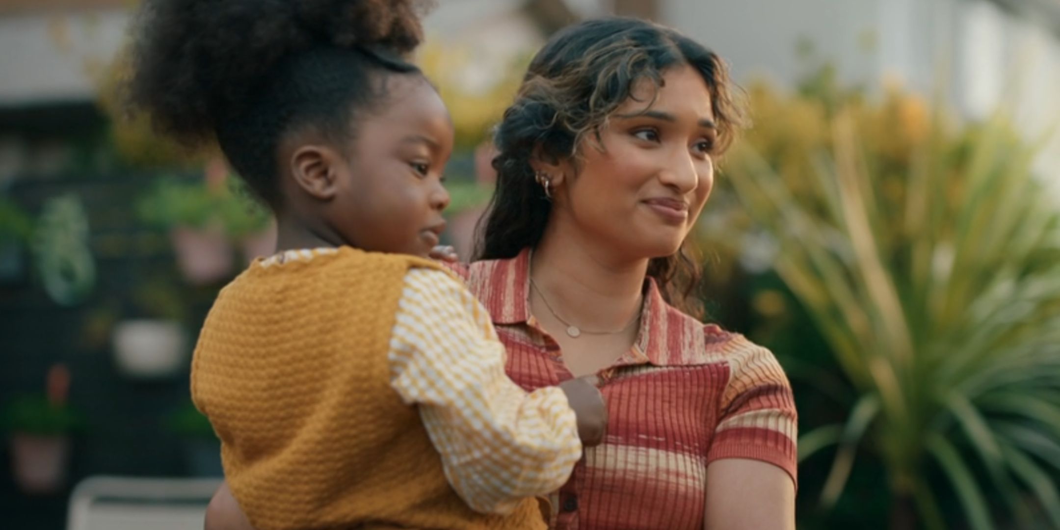 Varada Sethu as Belinda Chandra holding Poppy in Doctor Who