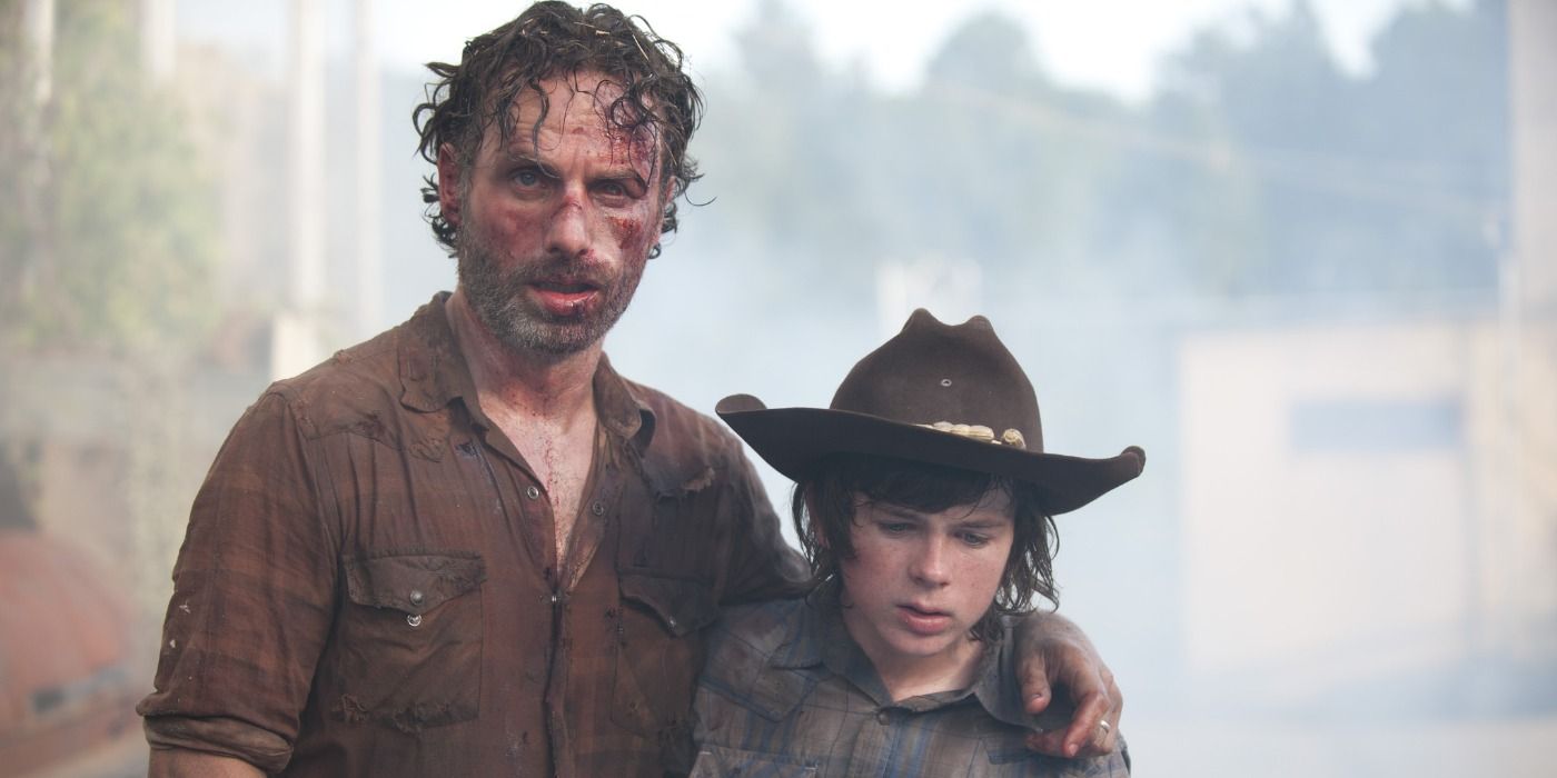 An injured Rick leans on his son Carl in The Walking Dead