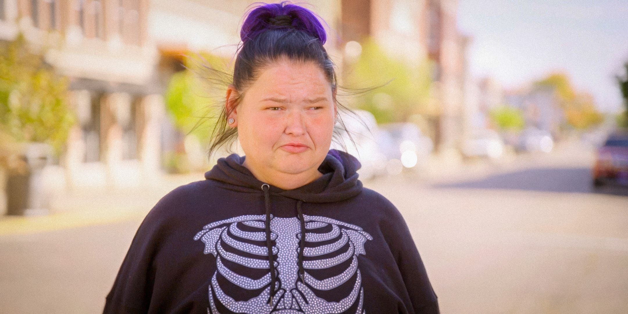 1000-Lb Sisters' Amy Slaton with a somber expression outside while wearing a skeleton sweatshirt