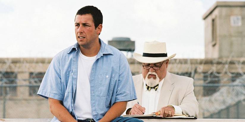 Adam Sandler sitting on a wall in The Longest Yard