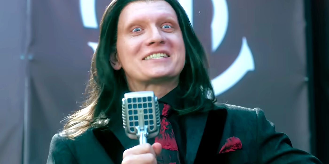 Anthony Carrigan as Calypso grinning maniacally while holding a microphone in Twisted Metal season 2