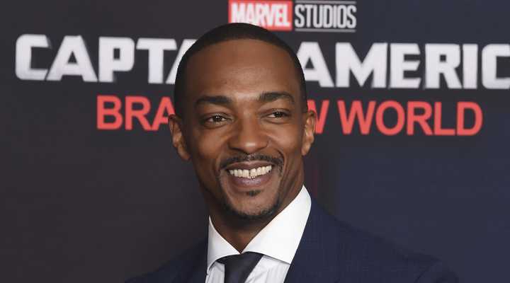 Anthony Mackie smiling on a red carpet for Captain America Brave New World