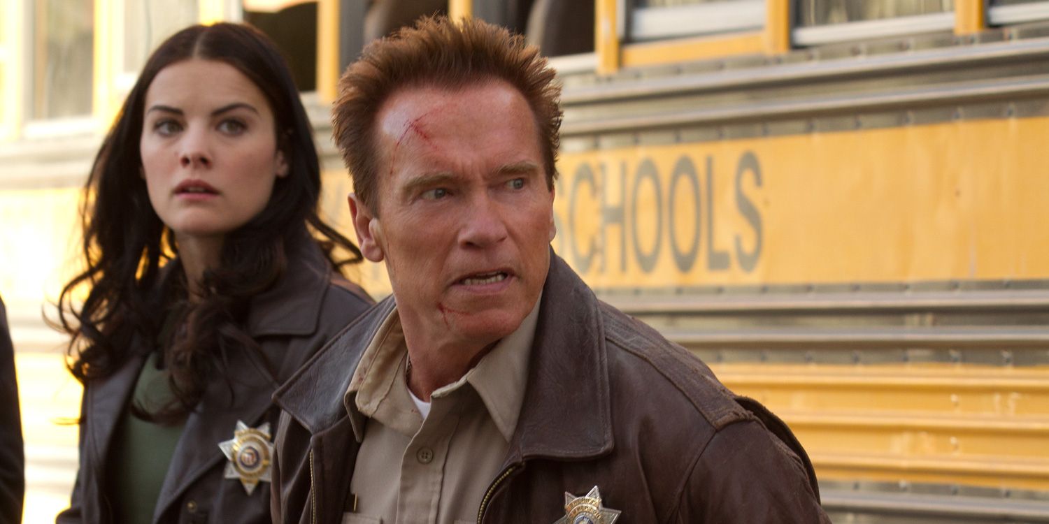Arnold Schwarzenegger and Jamie Alexander against a school bus in The Last Stand