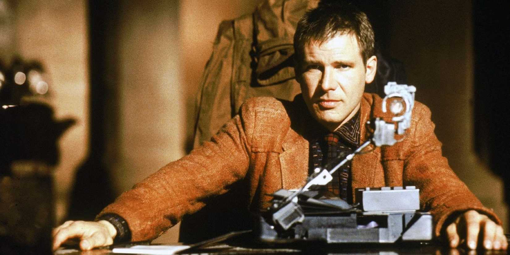 Harrison Ford as Deckard sits behind a desk in Blade Runner